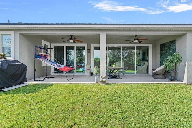 14897 Ellingsworth Ln, Winter Garden, FL 34787 - back of house featuring ceiling fan, a lawn, and stucco siding