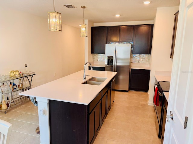 439 Cool Summer Ln, Davenport, FL 33837 - kitchen with appliances with stainless steel finishes, backsplash, light countertops, dark brown cabinetry, and recessed lighting