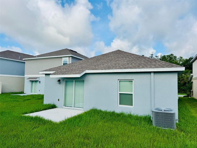 439 Cool Summer Ln, Davenport, FL 33837 - rear view of property with a yard, a shingled roof, stucco siding, and a patio area