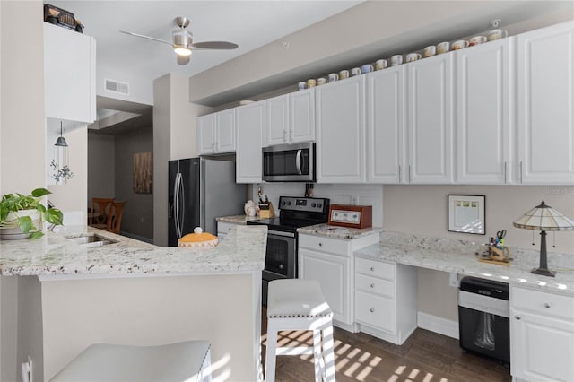 501 Mirasol Cir Unit 304, Kissimmee, FL 34747 - kitchen featuring stainless steel appliances, a ceiling fan, white cabinetry, decorative backsplash, and dark wood-style floors