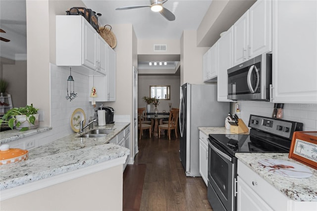 501 Mirasol Cir Unit 304, Kissimmee, FL 34747 - kitchen featuring appliances with stainless steel finishes, a ceiling fan, backsplash, and white cabinetry