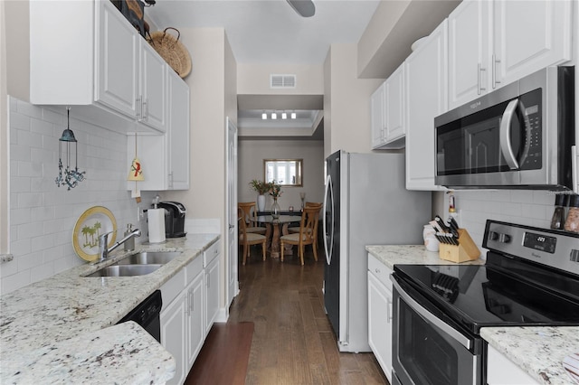 501 Mirasol Cir Unit 304, Kissimmee, FL 34747 - kitchen featuring stainless steel appliances, dark wood-type flooring, white cabinetry, and backsplash