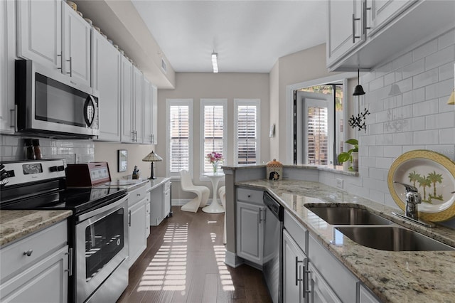 501 Mirasol Cir Unit 304, Kissimmee, FL 34747 - kitchen with appliances with stainless steel finishes, tasteful backsplash, white cabinetry, and dark wood-style floors