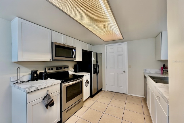 2242 Atrium Cir, Orlando, FL 32808 - kitchen featuring appliances with stainless steel finishes, light countertops, white cabinetry, and light tile patterned floors