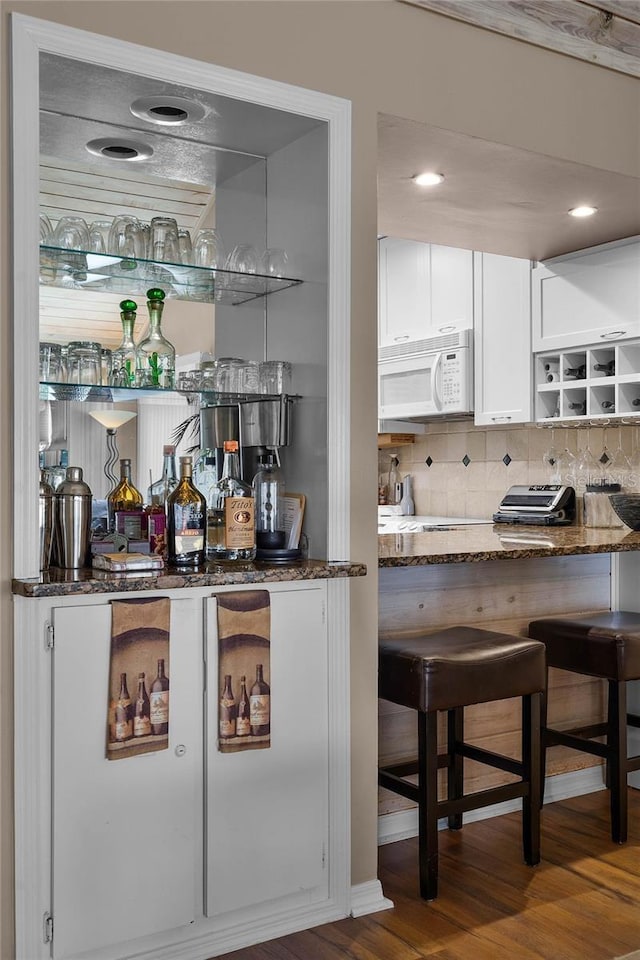1339 Villa Ln Unit 50, Apopka, FL 32712 - indoor dry bar featuring white microwave, wood finished floors, and decorative backsplash