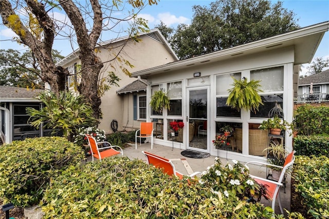 1339 Villa Ln Unit 50, Apopka, FL 32712 - back of house featuring stucco siding, a sunroom, and a patio area