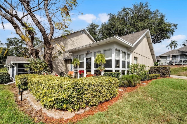 1339 Villa Ln Unit 50, Apopka, FL 32712 - view of front of home featuring a sunroom, a front lawn, and roof with shingles