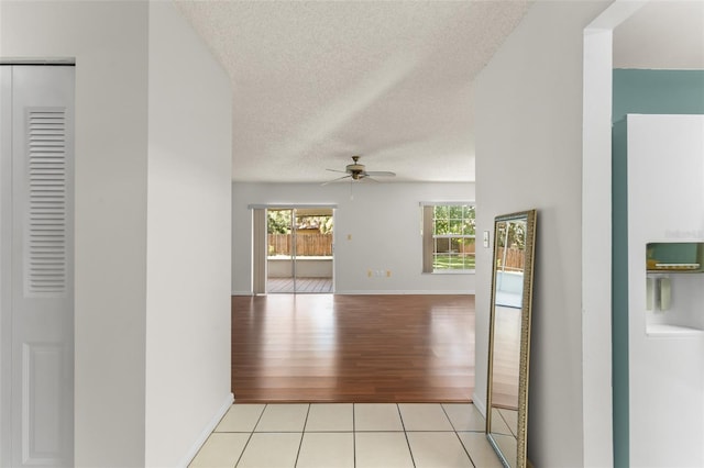 17 Rosewood Dr, Davenport, FL 33837 - hallway featuring healthy amount of natural light, a textured ceiling, and light wood-style floors