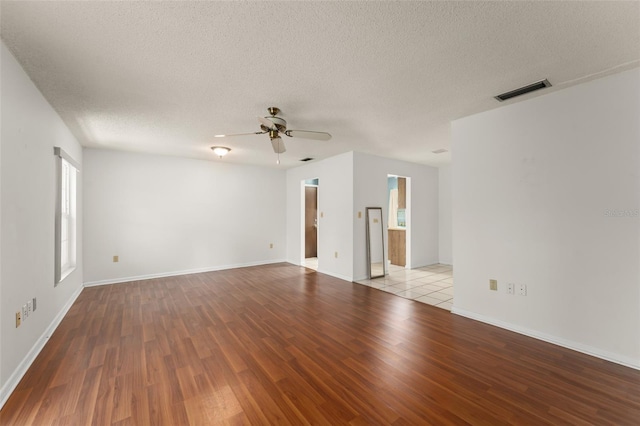 17 Rosewood Dr, Davenport, FL 33837 - empty room with wood finished floors, a ceiling fan, and a textured ceiling
