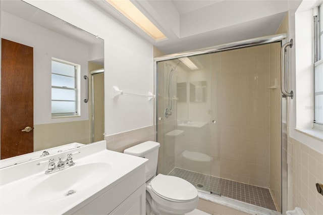 17 Rosewood Dr, Davenport, FL 33837 - full bathroom featuring tile walls, a stall shower, vanity, and wainscoting