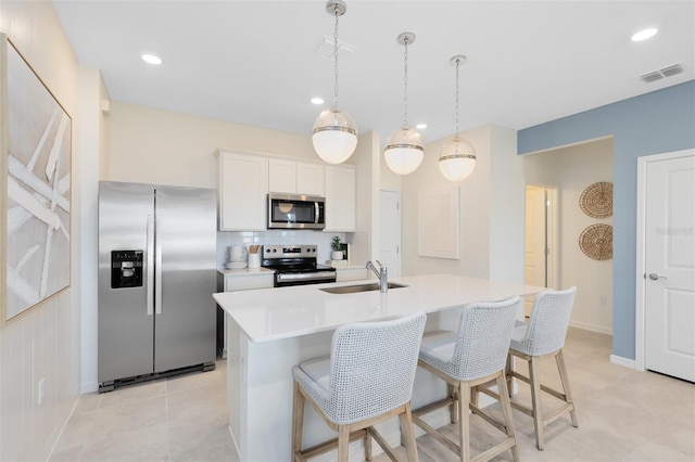 2304 Southbury Dr, Kissimmee, FL 34744 - kitchen with stainless steel appliances, tasteful backsplash, light countertops, an island with sink, and a kitchen breakfast bar