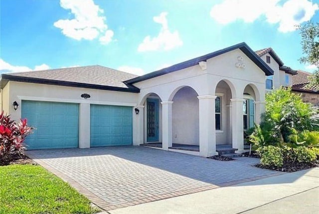 13542 Gorgona Isle Dr, Windermere, FL 34786 - mediterranean / spanish-style house featuring driveway, an attached garage, and stucco siding