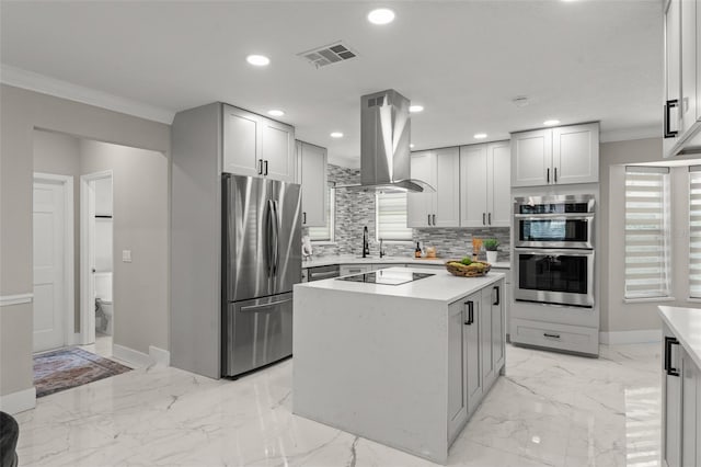 109 E 12th Ave, Windermere, FL 34786 - kitchen with appliances with stainless steel finishes, island exhaust hood, crown molding, tasteful backsplash, and light countertops