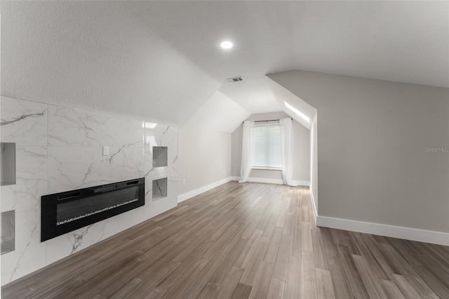 109 E 12th Ave, Windermere, FL 34786 - bonus room featuring a high end fireplace, wood finished floors, vaulted ceiling, and a textured ceiling