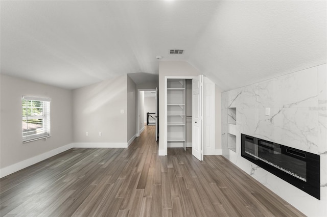109 E 12th Ave, Windermere, FL 34786 - unfurnished living room with a premium fireplace, lofted ceiling, and wood finished floors