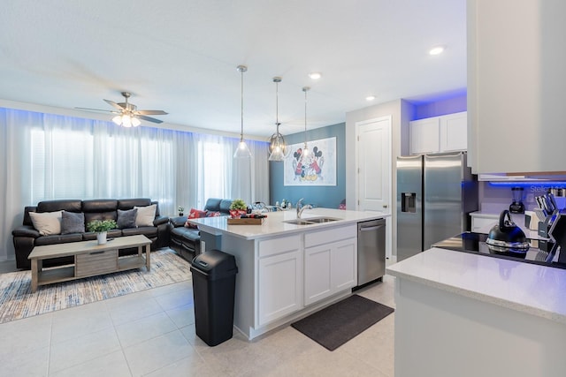 1030 Plantation Ln, Davenport, FL 33896 - kitchen with appliances with stainless steel finishes, light countertops, white cabinets, a ceiling fan, and an island with sink