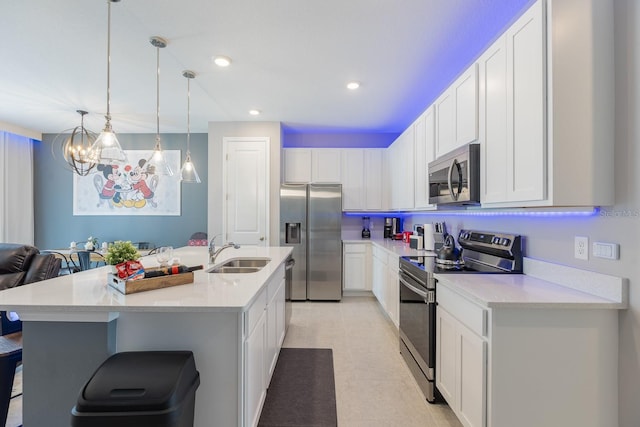 1030 Plantation Ln, Davenport, FL 33896 - kitchen featuring stainless steel appliances, white cabinetry, a chandelier, a kitchen bar, and pendant lighting
