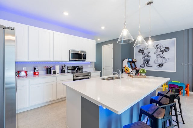 1030 Plantation Ln, Davenport, FL 33896 - kitchen with stainless steel appliances, a center island with sink, recessed lighting, white cabinets, and a kitchen breakfast bar