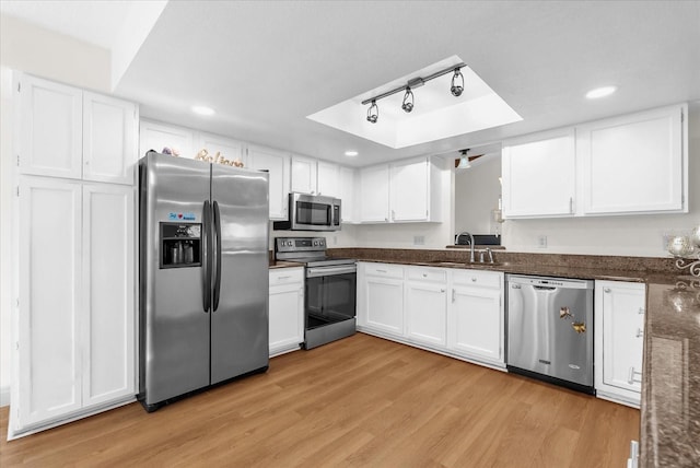 1157 E Winged Foot Cir, Winter Springs, FL 32708 - kitchen with stainless steel appliances, a tray ceiling, white cabinetry, light wood-type flooring, and recessed lighting