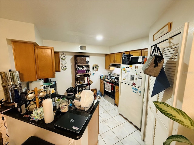 4690 Sussex Ter Unit 103, Orlando, FL 32811 - kitchen featuring freestanding refrigerator, stainless steel range with electric cooktop, brown cabinets, and ventilation hood