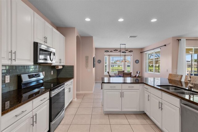 1758 Boat Launch Rd, Kissimmee, FL 34746 - kitchen featuring stainless steel appliances, decorative backsplash, white cabinetry, recessed lighting, and light tile patterned floors
