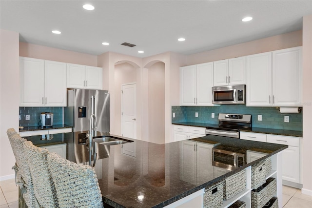 1758 Boat Launch Rd, Kissimmee, FL 34746 - kitchen with appliances with stainless steel finishes, decorative backsplash, white cabinetry, dark stone counters, and a large island