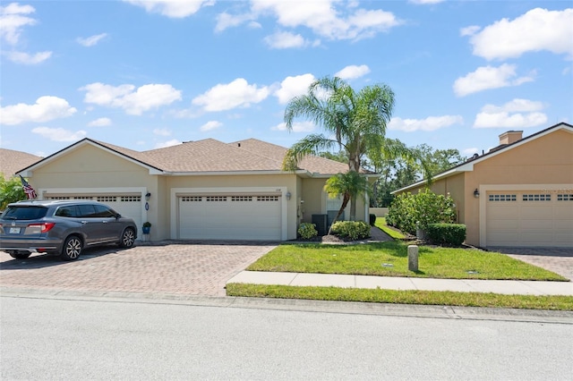 1218 Vienna Square Dr, Winter Haven, FL 33884 - view of front of home with driveway, a garage, a front lawn, and stucco siding