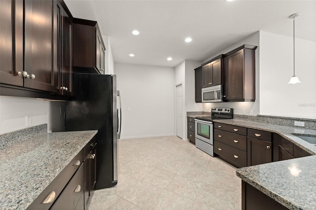 1218 Vienna Square Dr, Winter Haven, FL 33884 - kitchen featuring appliances with stainless steel finishes, light stone counters, dark brown cabinetry, light tile patterned floors, and hanging light fixtures
