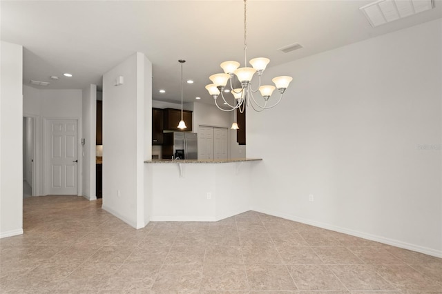 1218 Vienna Square Dr, Winter Haven, FL 33884 - kitchen featuring stainless steel refrigerator with ice dispenser, a chandelier, recessed lighting, stone countertops, and hanging light fixtures