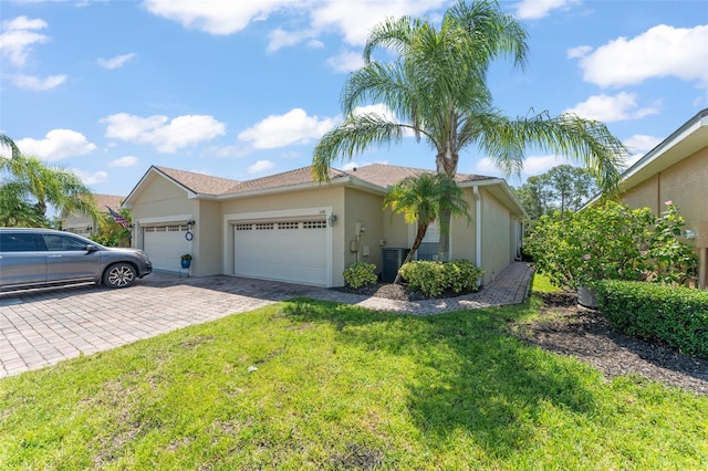 1218 Vienna Square Dr, Winter Haven, FL 33884 - view of front of house featuring a garage, decorative driveway, a front yard, and stucco siding