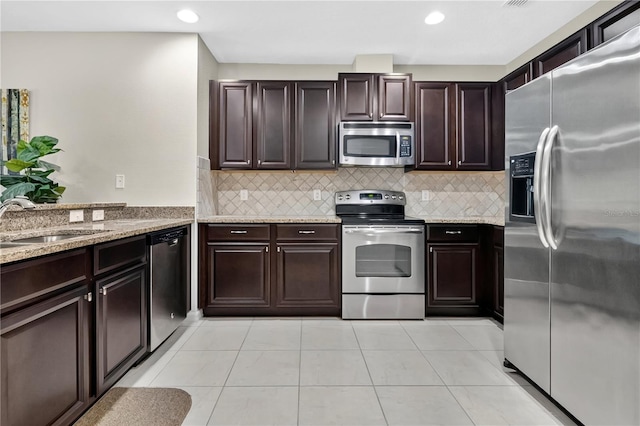 1414 Marsh Meadow Ln, Davenport, FL 33896 - kitchen featuring appliances with stainless steel finishes, light stone countertops, tasteful backsplash, recessed lighting, and dark brown cabinetry