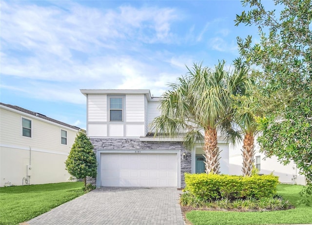 8940 Zurich Ln, Kissimmee, FL 34747 - view of front facade with decorative driveway, a garage, stone siding, and a front yard