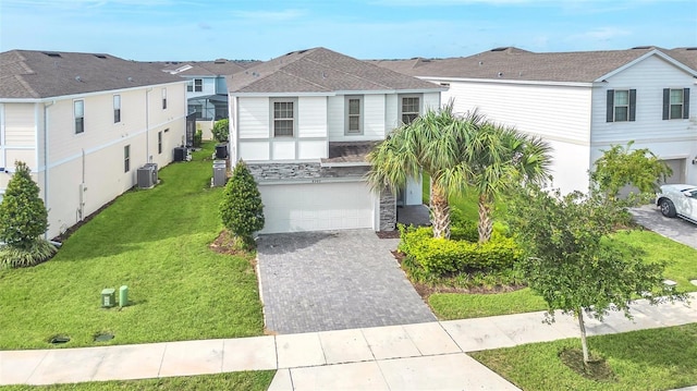 8940 Zurich Ln, Kissimmee, FL 34747 - view of front of house featuring an attached garage, decorative driveway, a residential view, stone siding, and a front lawn