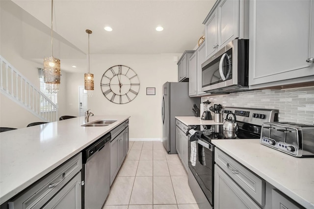 8940 Zurich Ln, Kissimmee, FL 34747 - kitchen featuring stainless steel appliances, gray cabinetry, decorative backsplash, pendant lighting, and recessed lighting