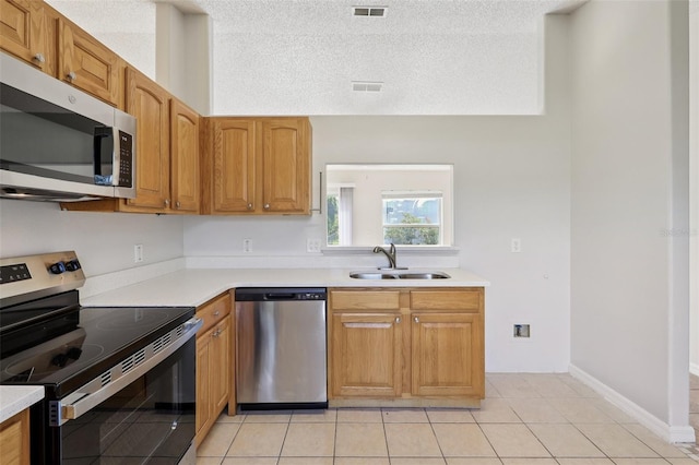 1742 Van Allen Cir, Deltona, FL 32738 - kitchen featuring stainless steel appliances, light tile patterned floors, light countertops, a textured ceiling, and brown cabinets