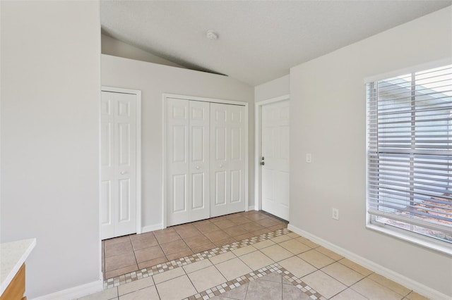 1742 Van Allen Cir, Deltona, FL 32738 - unfurnished bedroom featuring light tile patterned flooring, two closets, and vaulted ceiling