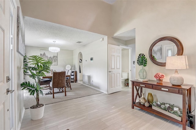 569 Yearling Cove Loop, Apopka, FL 32703 - foyer with arched walkways, wood finished floors, and a textured ceiling