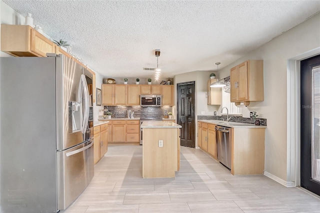 569 Yearling Cove Loop, Apopka, FL 32703 - kitchen featuring appliances with stainless steel finishes, light brown cabinets, a kitchen island, light countertops, and tasteful backsplash