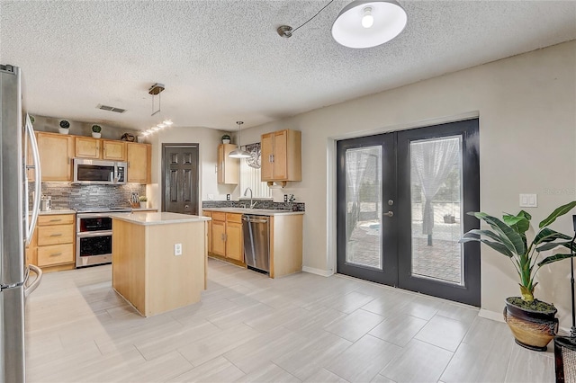 569 Yearling Cove Loop, Apopka, FL 32703 - kitchen with french doors, stainless steel appliances, decorative backsplash, a center island, and a textured ceiling