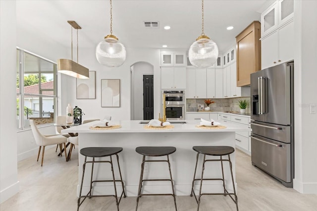 619 Largovista Dr, Oakland, FL 34787 - kitchen with appliances with stainless steel finishes, light countertops, a center island, backsplash, and a breakfast bar