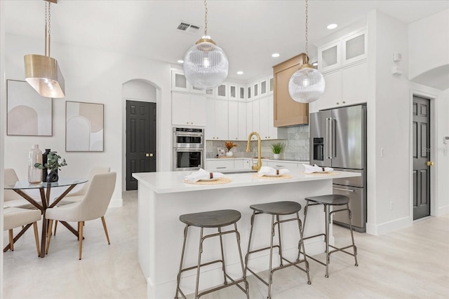 619 Largovista Dr, Oakland, FL 34787 - kitchen featuring stainless steel appliances, light countertops, tasteful backsplash, a center island with sink, and a kitchen breakfast bar