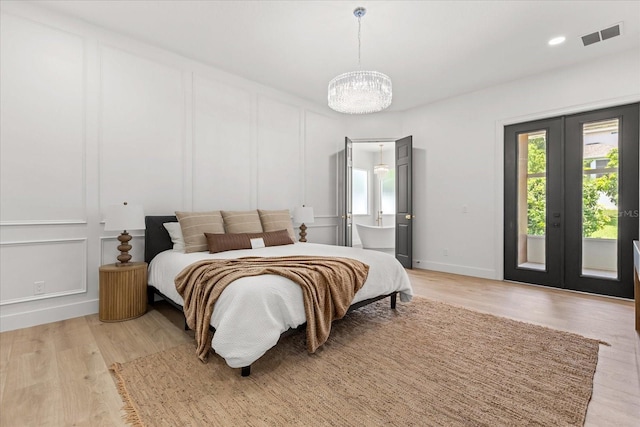 619 Largovista Dr, Oakland, FL 34787 - bedroom with a decorative wall, a chandelier, access to outside, french doors, and light wood finished floors