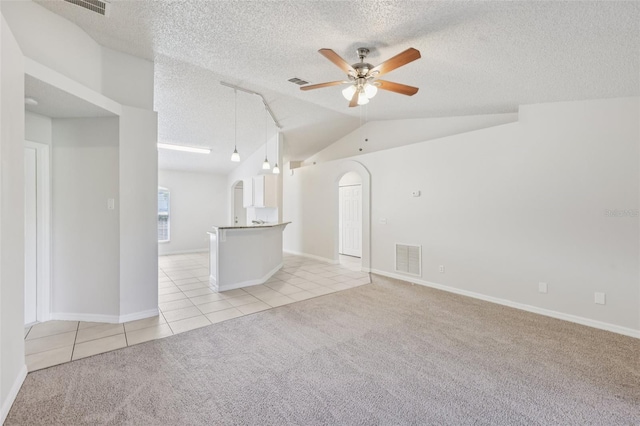 1082 Worthington Dr, Deltona, FL 32738 - spare room with light tile patterned floors, ceiling fan, light colored carpet, a textured ceiling, and arched walkways