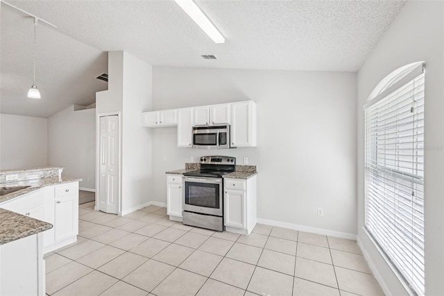 1082 Worthington Dr, Deltona, FL 32738 - kitchen featuring stainless steel appliances, vaulted ceiling, white cabinetry, a textured ceiling, and light stone countertops