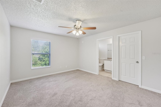 1082 Worthington Dr, Deltona, FL 32738 - unfurnished bedroom with light carpet, a textured ceiling, ensuite bath, and a ceiling fan