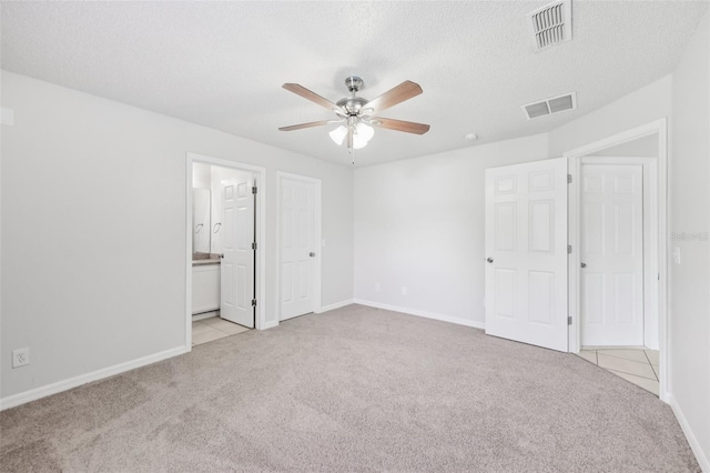 1082 Worthington Dr, Deltona, FL 32738 - unfurnished bedroom featuring light colored carpet, ensuite bathroom, ceiling fan, and a textured ceiling