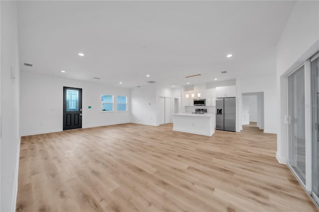 9333 Hialeah Ter, Port Charlotte, FL 33981 - unfurnished living room with light wood-style floors and recessed lighting