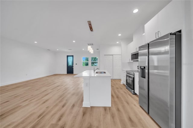 9333 Hialeah Ter, Port Charlotte, FL 33981 - kitchen featuring stainless steel appliances, white cabinets, light wood finished floors, light countertops, and pendant lighting