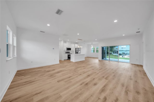 9333 Hialeah Ter, Port Charlotte, FL 33981 - unfurnished living room with recessed lighting and light wood-style flooring