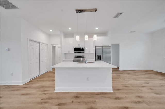 9333 Hialeah Ter, Port Charlotte, FL 33981 - kitchen with stainless steel appliances, white cabinets, light countertops, light wood-style floors, and recessed lighting